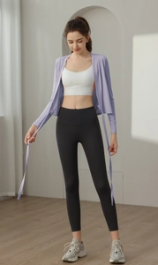 Detail view of light purple yoga wrap top with white sports bra and black leggings set