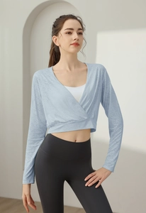Detail of light blue wrap-style yoga top with breathable nylon fabric and sleek fit