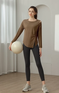 Detail of coffee-colored cutout yoga top with side slit and pleated waist design
