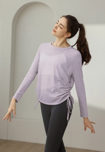 Detail of light purple yoga shirt featuring side drawstrings and soft textured fabric