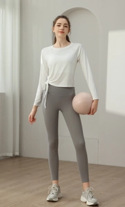 Detail view of white slim-fit yoga top featuring adjustable side drawstring and long sleeves