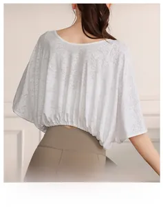 Macro detail of breathable white mesh fabric on a batwing sleeve yoga top for women
