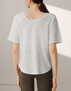 Detail of cross-strap open back design on white burnout camo yoga t-shirt