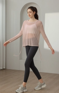 Detail of pink long-sleeved yoga cover-up with drawstring sides and mesh texture
