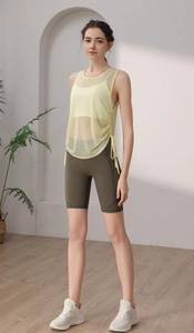 Pale yellow mesh yoga top with open back paired with olive green high waist cycling shorts