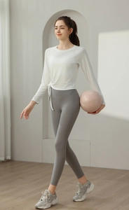 Detail of white long sleeve yoga top featuring adjustable side drawstring and slim fit