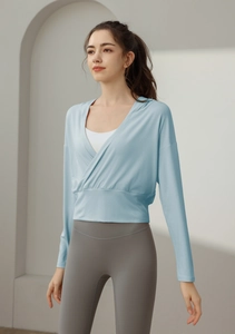 Détail de la coupe croisée d'un haut de yoga bleu clair à manches longues pour femmes