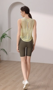 Detail of breathable yellow mesh yoga tank top with vertical back slit design