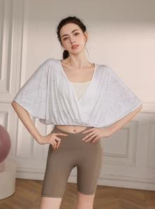 Detail of white jacquard yoga top with breathable texture and batwing sleeve design