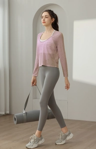 Détail du haut de sport lilas respirant sur un soutien-gorge de yoga blanc et legging gris