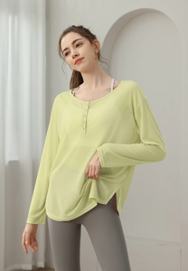 Détail du haut de yoga côtelé vert clair à manches longues avec boutons henley respirant