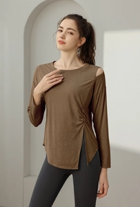 Detailed side view of brown yoga top with ruching, shoulder cutout and side slit