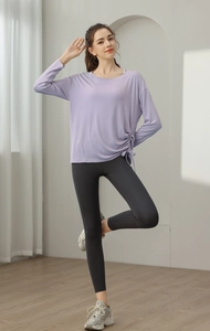 Detail des lavendelfarbenen Yoga-Oberteils mit Kordelzug und anthrazitfarbener Leggings