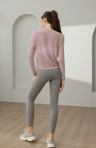 Vue arrière d'une femme portant un haut de yoga lilas respirant et un legging de sport gris