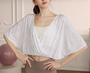 Detail of white batwing sleeve yoga top with cross V-neck and breathable mesh texture