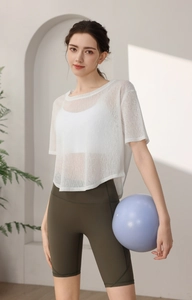 Vue détaillée du haut de sport en maille blanche et du short de fitness vert olive à taille haute