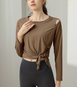 Detail view of brown yoga top featuring one-shoulder cutout and side waist tie design