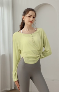 Détail du haut de yoga vert clair avec taille nouée et texture de tissu côtelé