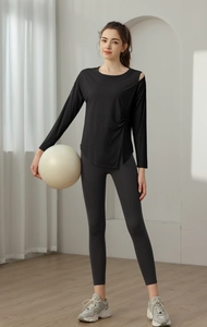 Detail of ruched side and asymmetric shoulder on breathable yoga top with grey leggings