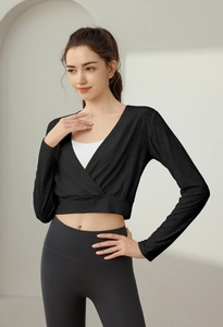 Close-up of black breathable nylon jacquard long-sleeved sports wrap top and inner white bra