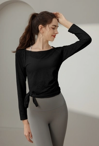 Slim fit black yoga top featuring side tie-knot detail and breathable jacquard fabric