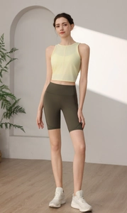 Detailansicht vom hellgelben Yoga-Top mit Netzschicht und olivgrüner Radlerhose