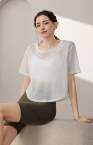 Détail du haut de sport en mesh blanc avec ourlet incurvé et texture translucide