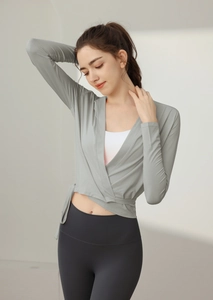 Close-up of light gray long-sleeve cross-tie yoga top with premium breathable fabric