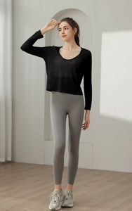 Détail du haut de yoga noir à manches longues et du legging gris à taille haute