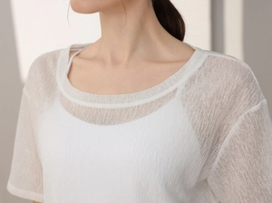 Détail d'un haut de yoga en maille blanche semi-transparente avec texture verticale aérée