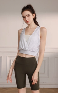 Close-up of a white layered V-neck sports vest paired with olive green yoga shorts