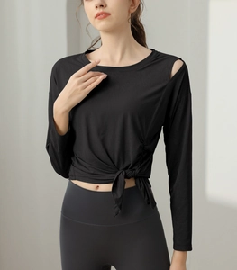 Detail of black long-sleeved yoga top with side drawstring tie and shoulder cutout