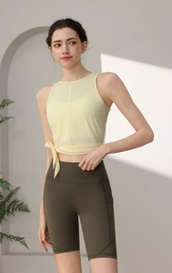Detail des Yoga-Sets mit hellgelbem Mesh-Tanktop und olivgrünen High-Waist-Shorts