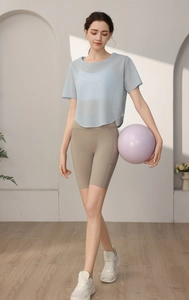 Détail d'un haut de yoga en maille bleu clair avec un short de cyclisme kaki taille haute