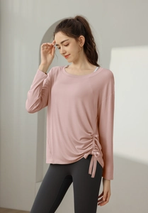 Detail eines rosa langärmligen Yoga-Tops mit verstellbarem Kordelzug und gerafftem Saum