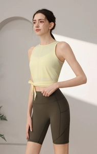 Detail von hellgelbem Yoga-Mesh-Top und olivgrüner High-Waist-Radlerhose für Damen