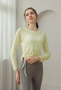 Detail of drawstring cinched side on light green long sleeve yoga top with ruched texture