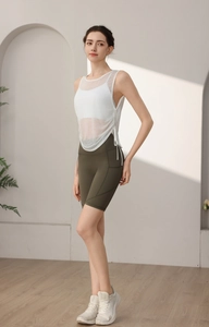Detail view of white layered yoga top with mesh overlay and drawstring side ruching