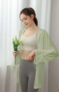 Detail of light green yoga cover-up showing drawstring sleeves and translucent fabric
