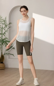 Detail of white mesh breathable yoga tank top with side drawstring and olive green cycling shorts