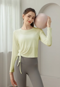 Detail view of light green yoga top with side drawstring design and breathable mesh fabric