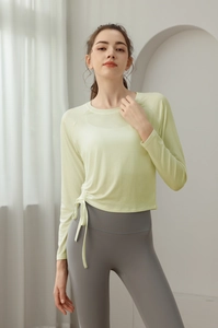 Detail of light green yoga top with side drawstring design and ruched slim-fit hem