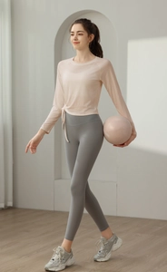 Detail showing pink yoga top with side drawstring design and lightweight breathable fabric