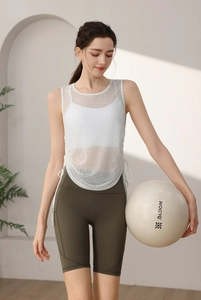 Detail of white mesh yoga top with waist drawstring and high-waisted olive cycling shorts