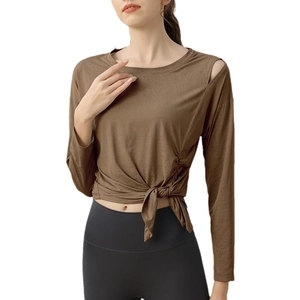 Brown long sleeve yoga top with shoulder cutout and tie-knot waist detail