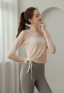 Detail view of the side drawstring feature and soft fabric texture on the slim yoga top