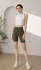 Detailansicht von weißem Yoga Top und olivgrüner High Waist Biker-Shorts für Fitness