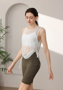 Detail of white mesh yoga tank top with side drawstrings and sheer breathable fabric