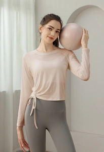 Detail of pink long sleeve yoga top with side drawstring ruching and crew neck cut