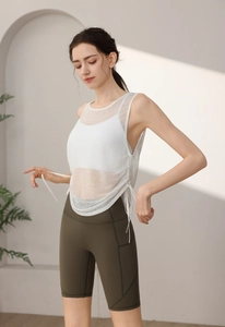 Detail of white mesh yoga tank top with side pocket cycling shorts in a soft natural light